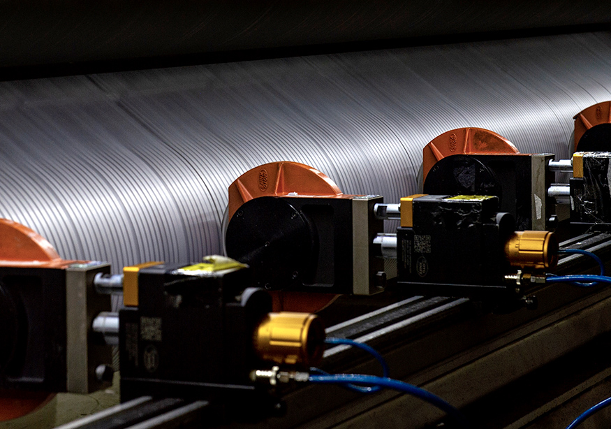 Industrial machinery processing grooved material through orange rolling mechanisms