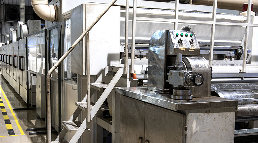 Large industrial machine with metal stairs and control panel in a factory