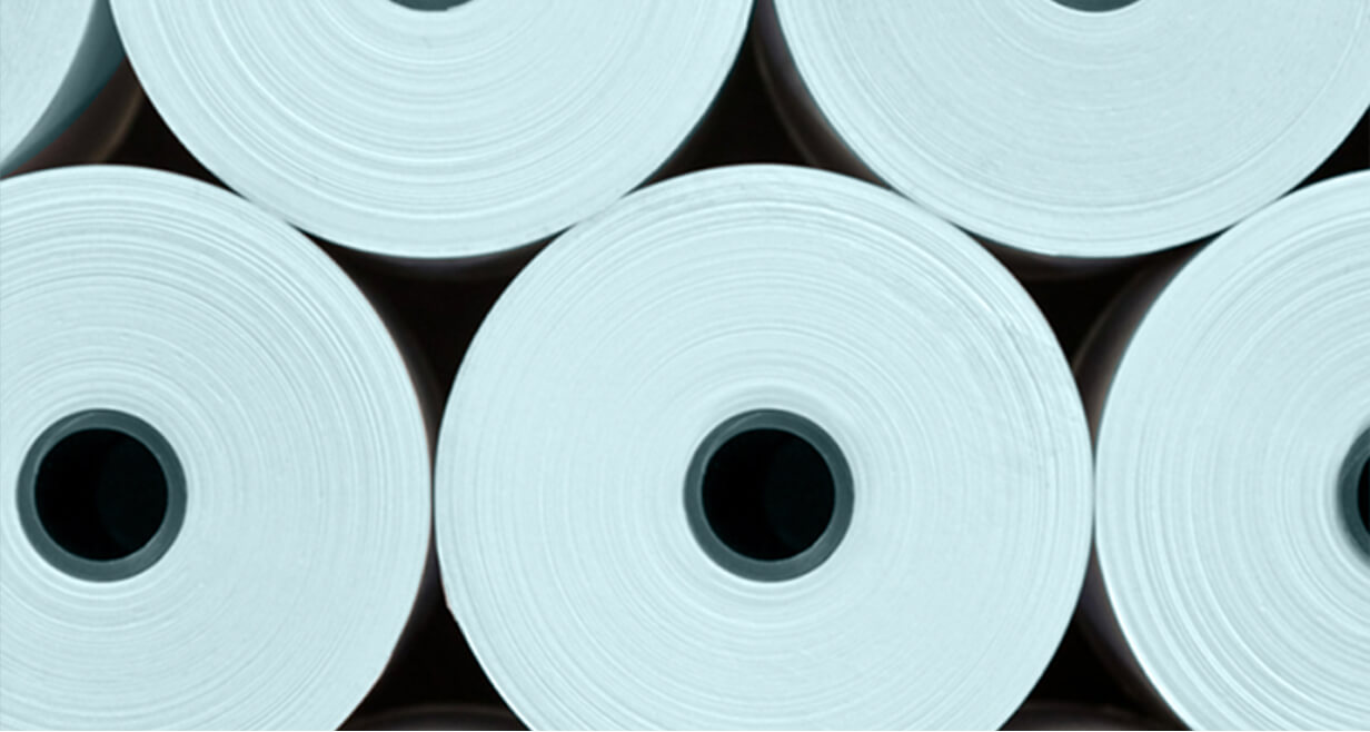 Tumpukan gulungan kain nonwoven putih besar dilihat dari ujungnya